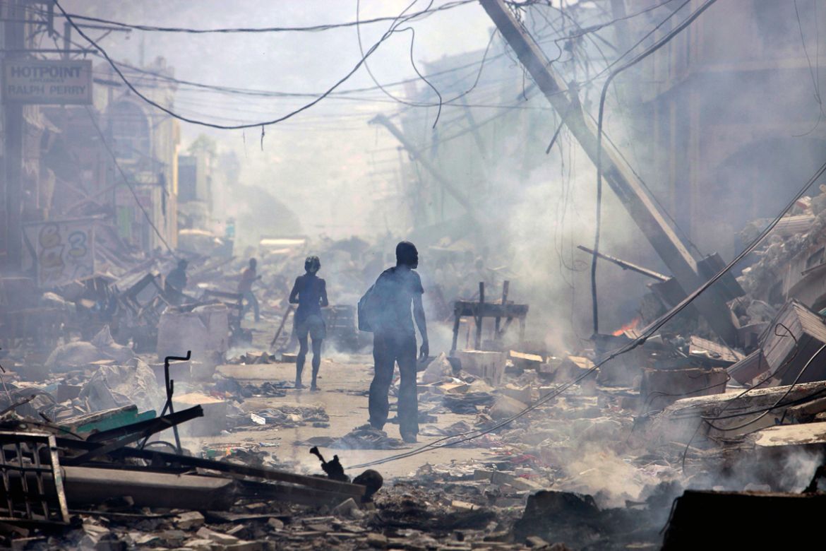 - In this Jan. 17, 2010 file photo, people walk down a street amid earthquake rubble in Port-au-Prince, haiti. In 2010 crisis has piled upon crisis in Haiti. More than 230,000 are believed to have die
