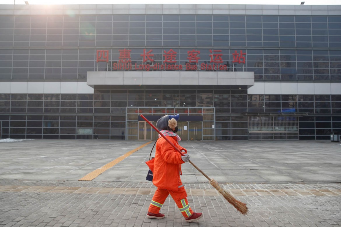 A cleaner walks past the Sihui Long Distance Bus Station in Beijing after the city has stoped inter-province buses services as the country is hit by an outbreak of the new coronavirus, January 26, 202