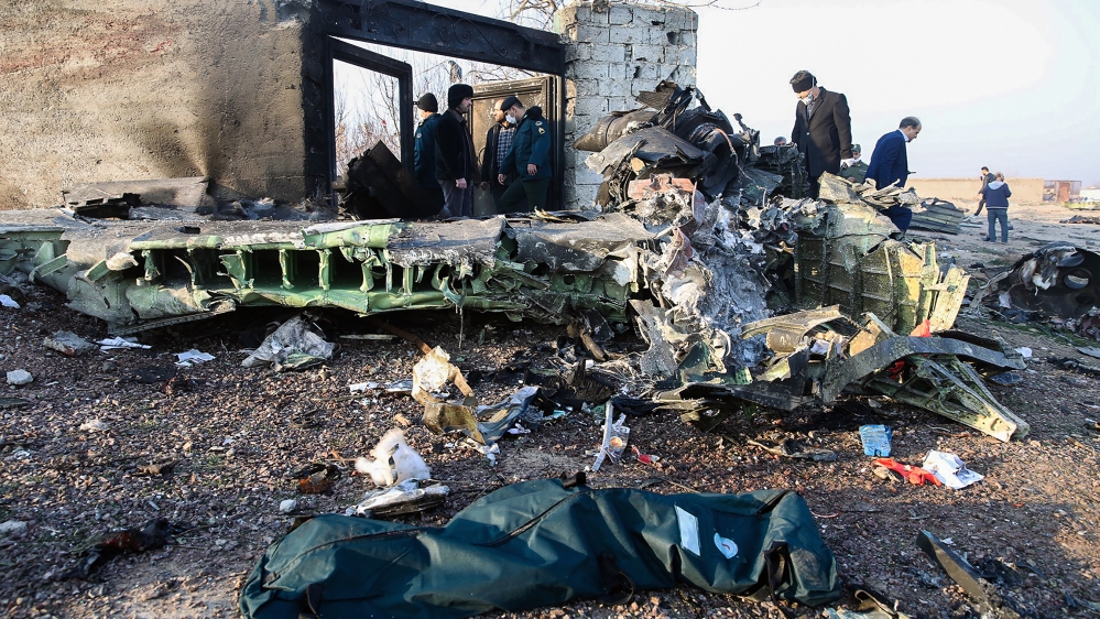 People stand near the wreckage after a Ukrainian plane carrying 176 passengers crashed near Imam Khomeini airport in Tehran on January 8, 2020. All 176 people on board a Ukrainian passenger plane were