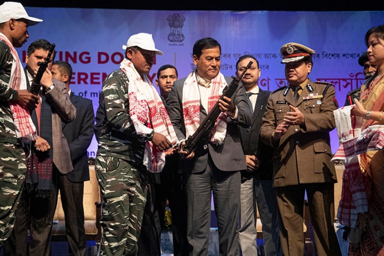 Assam Chief minister Sarbananda Sonowal, third from right, receives arms from one of the rebels who surrendered during a ceremony in Gauhati, India, Thursday, Jan. 23, 2020. More than 600 insurgents b