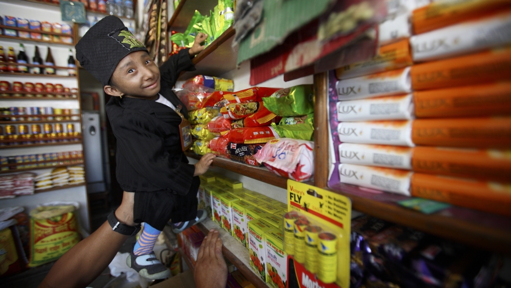 World shortest living man, Magar, tries to take a packet of noodles at a local grocery shop near his home in Pokhara
