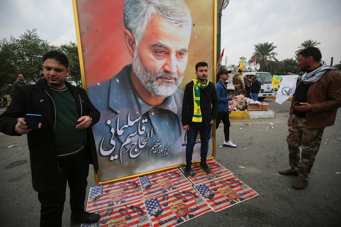 Supporters of the Hashed al-Shaabi paramilitary force and Iraq''s Hezbollah brigades pose for a picture next to a poster of Iranian military commander Qasem Soleimani (portrait) during a funeral, for S