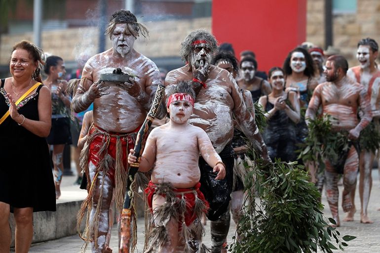 boriginal people carry a small fire at the beginning of the Wugulora Indigenous Morning Ceremony as part of Australia Day celebrations in Sydney, Australia, Sunday, Jan. 26, 2020. (AP Photo/Rick Rycro