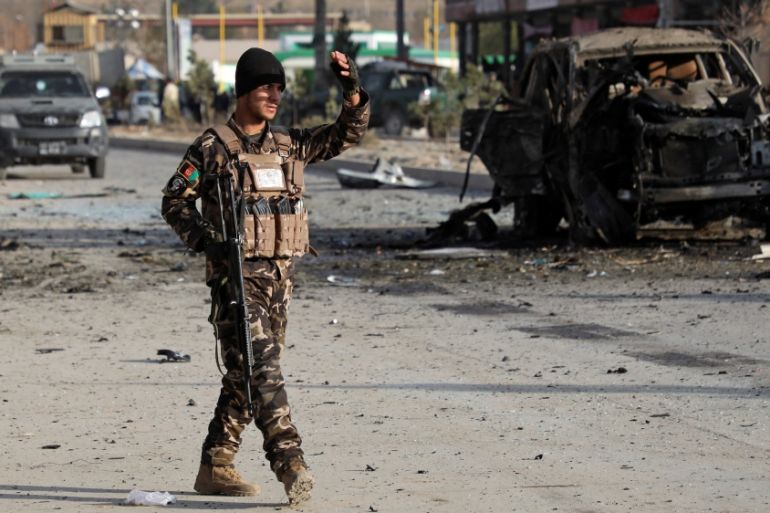 A member of the Afghan security forces keeps watch at the site of a suicide blast in Kabul, Afghanistan
