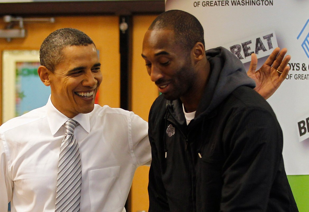 U.S. President Barack Obama slaps Kobe Bryant on the back as they put together care packages for the military and homeless people at the Boys and Girls Club of Washington, December 13, 2010. REUTERS