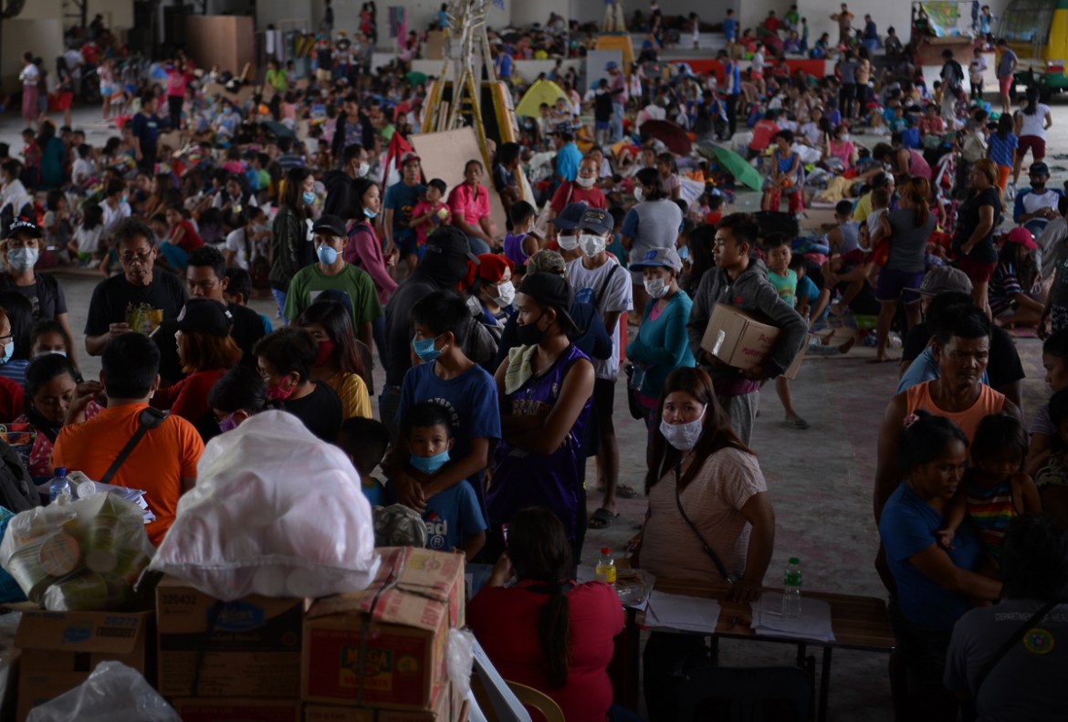 Evacuees from towns affected by the eruption of Taal volcano queue up at an evacuation center in Tanauan town, Batangas province south of Manila on January 14, 2020. - Taal volcano in the Philippines