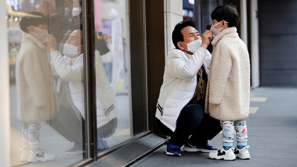 A man and a boy wear masks to prevent contracting a new coronavirus at Myeongdong shopping district in Seoul
