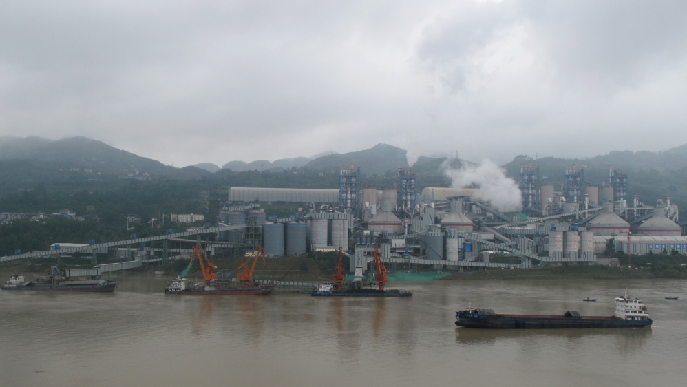 Cement plant is seen by the Yangtze river near Fuling county in Chongqing