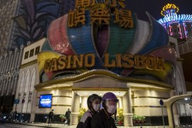 Macau's casinos Grand Lisboa with passersby in the foreground.