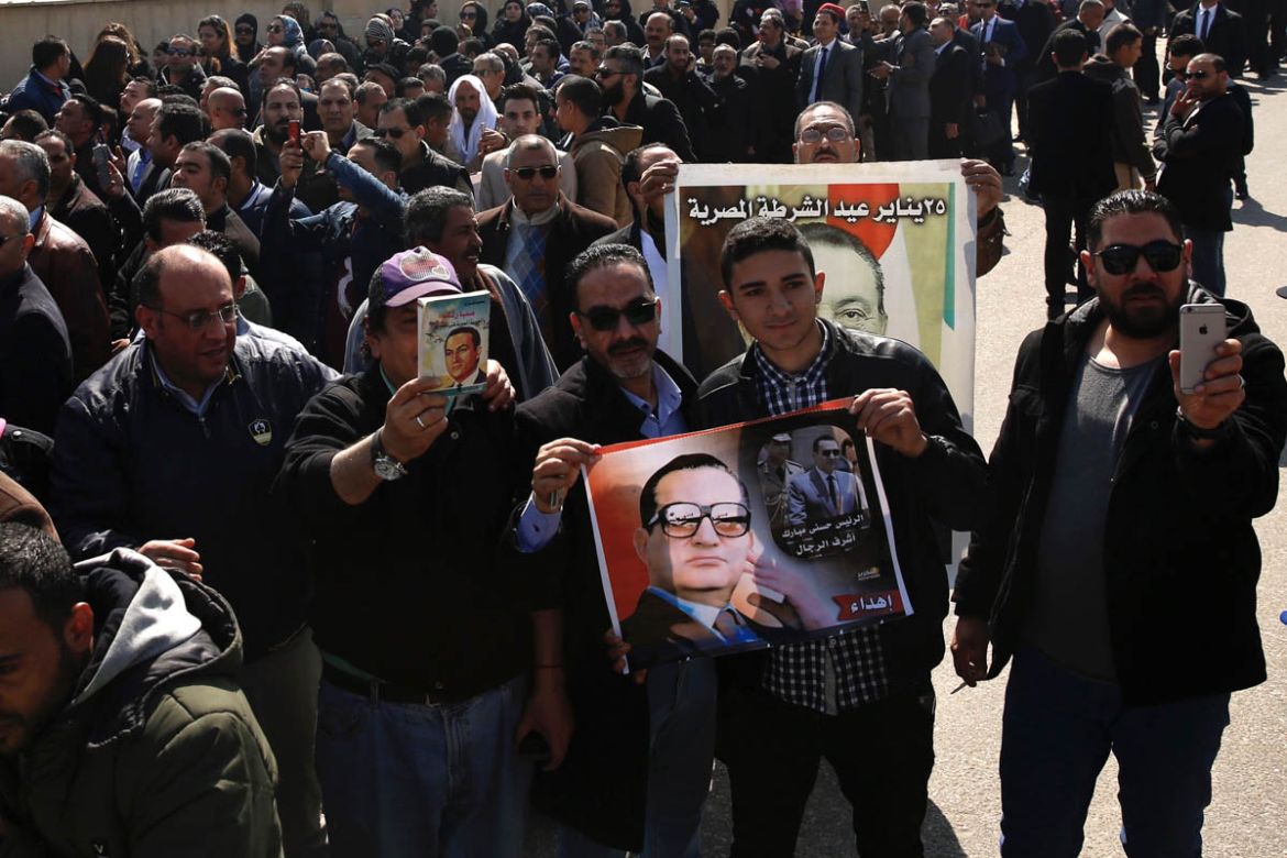 epa08248556 People hold photos of late former Egyptian President Hosni Mubarak as they gather outside Mosheer Tantawy mosque ahead of Mubarak''s funeral, in Cairo, Egypt, 26 February 2020. Mubarak died