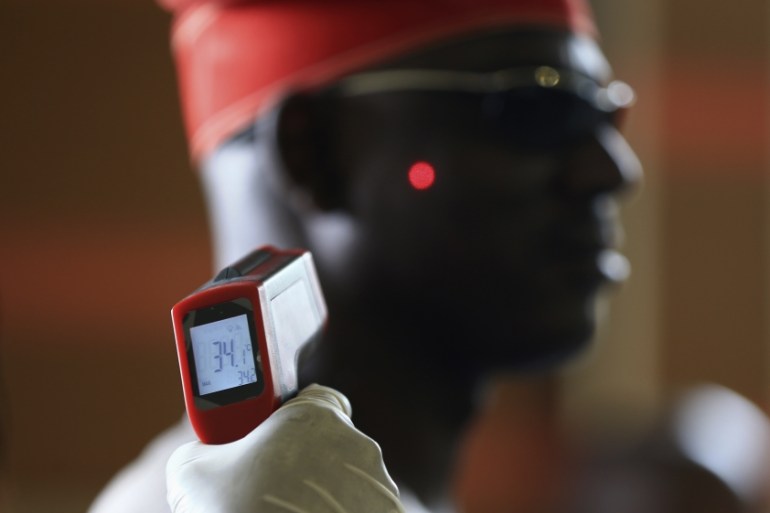 Man has his temperature taken using an infrared digital laser thermometer at the Nnamdi Azikiwe International Airport in Abuja