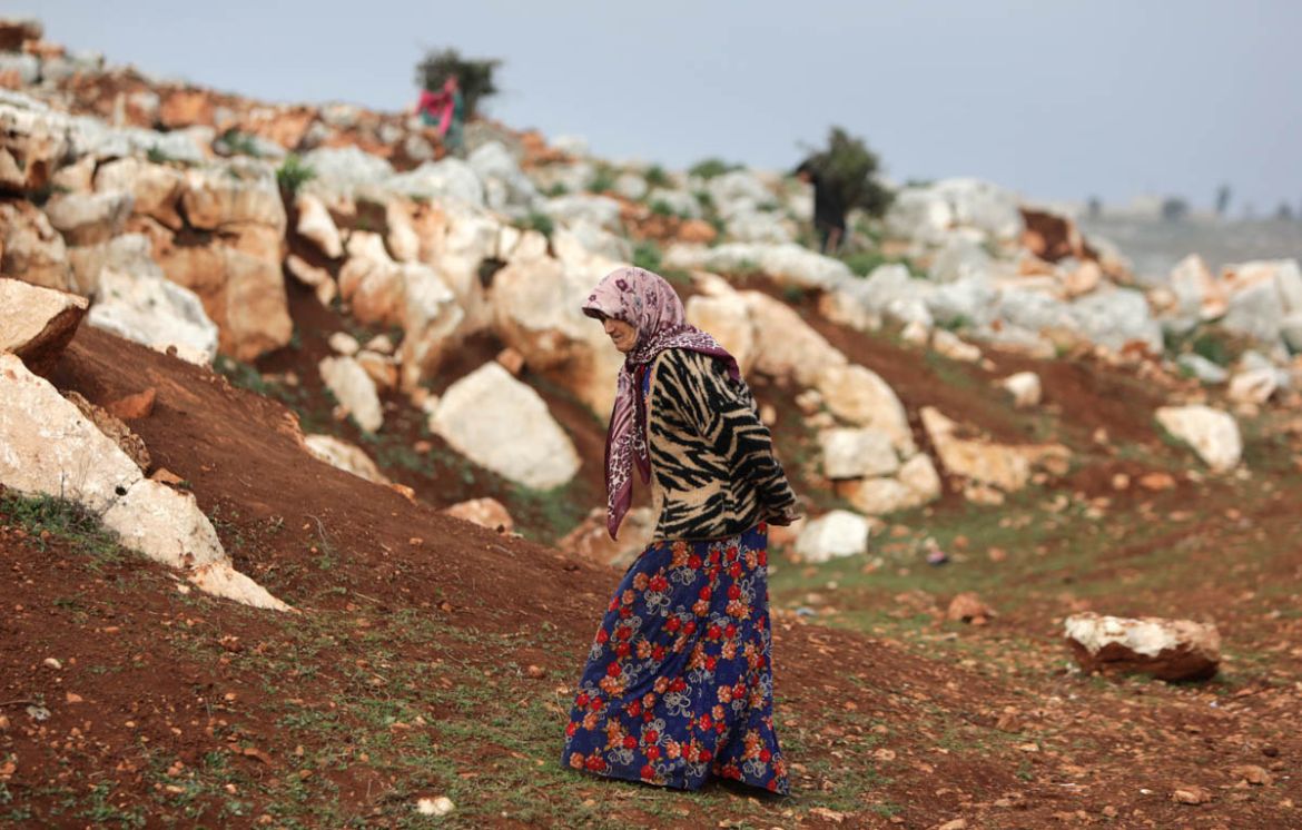 A Syrian woman walks at a makeshift camp for displaced people who fled pro-regime forces attacks in the Idlib and Aleppo provinces, on February 18, 2020 north of the city of Idlib, near the Turkish bo