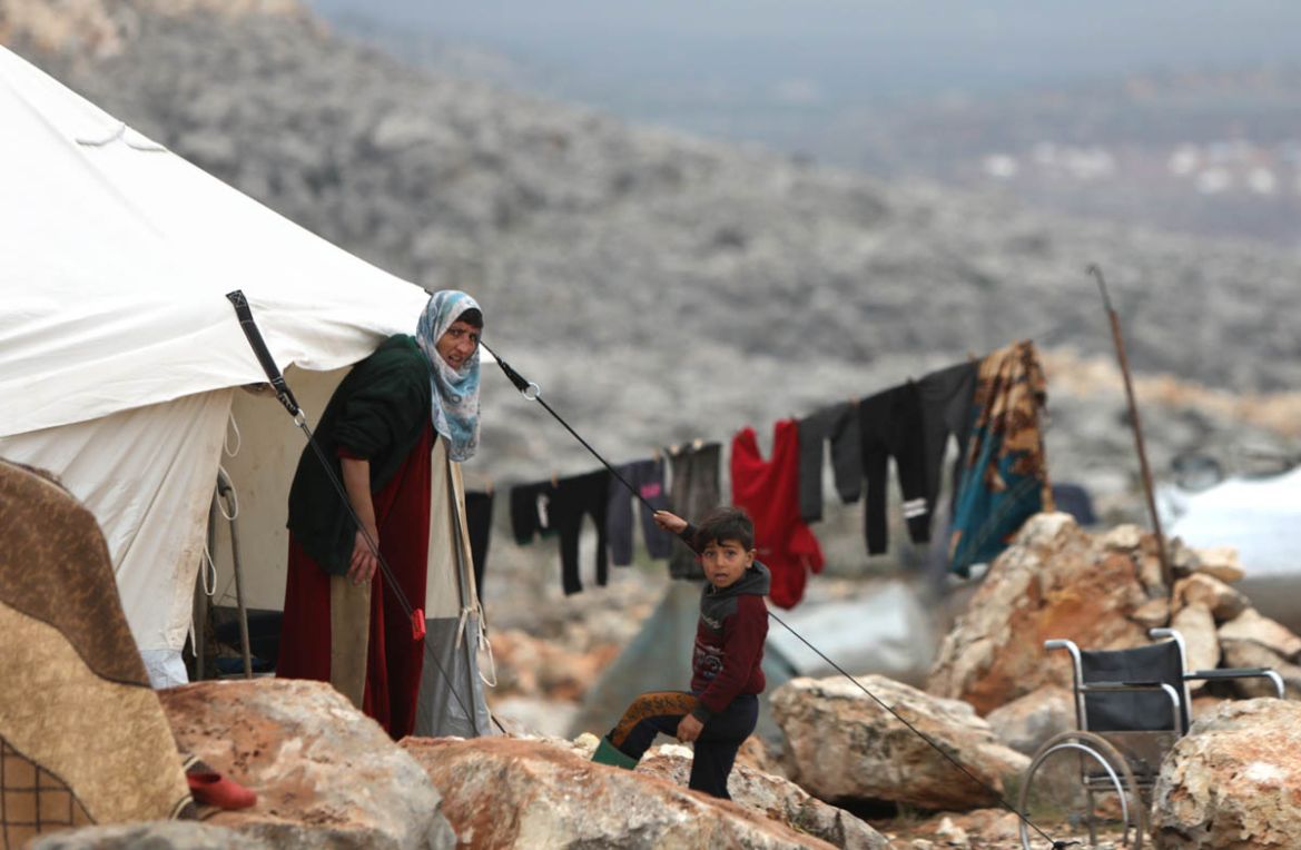 Syrians who fled pro-regime forces attacks in the Idlib and Aleppo provinces are pictured at a makeshift camp for displaced people on February 18, 2020 north of the city of Idlib, near the Turkish bor