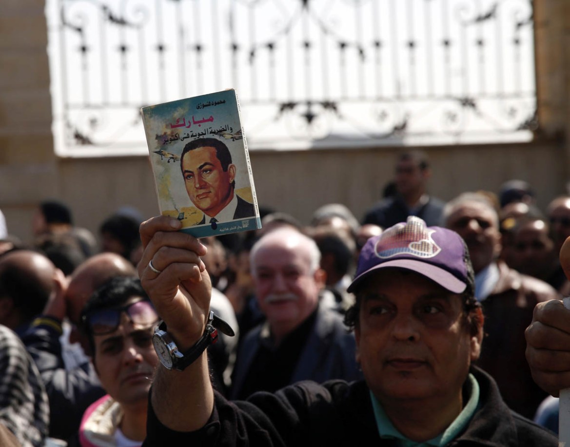 epa08248552 People hold photos of late former Egyptian President Hosni Mubarak as they gather outside Mosheer Tantawy mosque ahead of Mubarak''s funeral, in Cairo, Egypt, 26 February 2020. Mubarak died