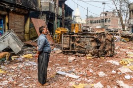 A resident look at burnt-out and damaged residential premises and shops following clashes between people supporting and opposing a contentious amendment to India''s citizenship law, in New Delhi on Feb