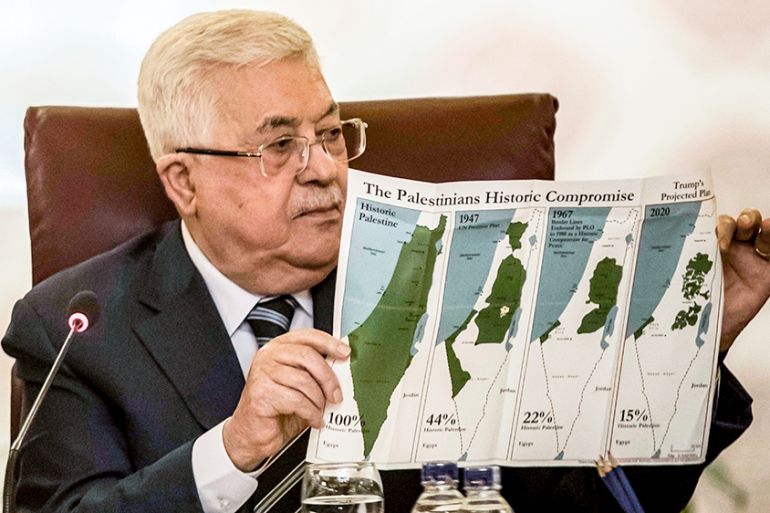 Palestinian president Mahmud Abbas holds a placard showing maps of (L to R) historical Palestine, the 1947 United Nations partition plan on Palestine, the 1948-1967 borders between the Palestinian ter