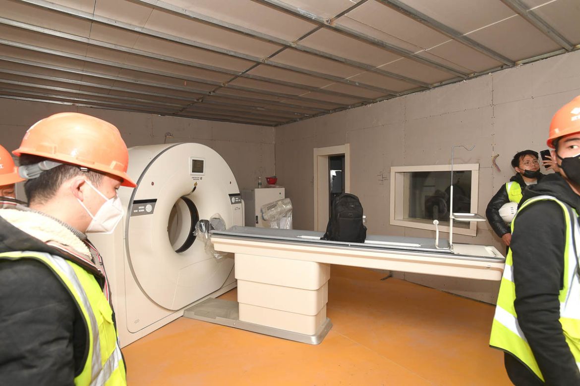 Workers walk by a new computerized tomography (CT) scanner in a room in Huoshenshan Hospital in Wuhan, Hubei Province, China, 02 February 2020. The construction of the 1,000-bed temporary field hospit