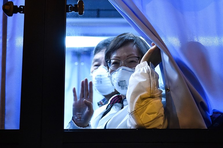 A US passenger waves to reporters while arriving at the Haneda Airport, in Tokyo on February 17, 2020 after disembarking in Yokohama from the Diamond Princess cruise ship, where people are quarantined