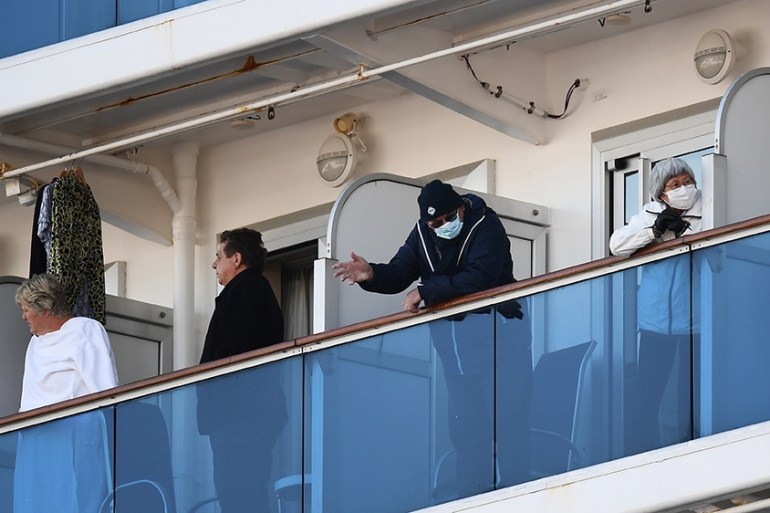 Passengers stand on balconies on the Diamond Princess cruise ship, with around 3,600 people quarantined onboard due to fears of the new coronavirus, at the Daikoku Pier Cruise Terminal in Yokohama por