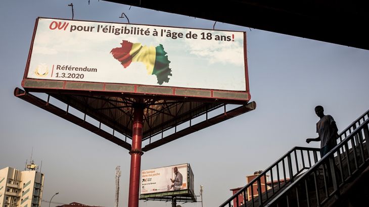 A man walks in front of a billboard advertising "Yes" to the referendum in Conakry on February 26, 2020. - On March 1st, 2020 Guinea Conakry will hold a referendum to change the constitution. If succe
