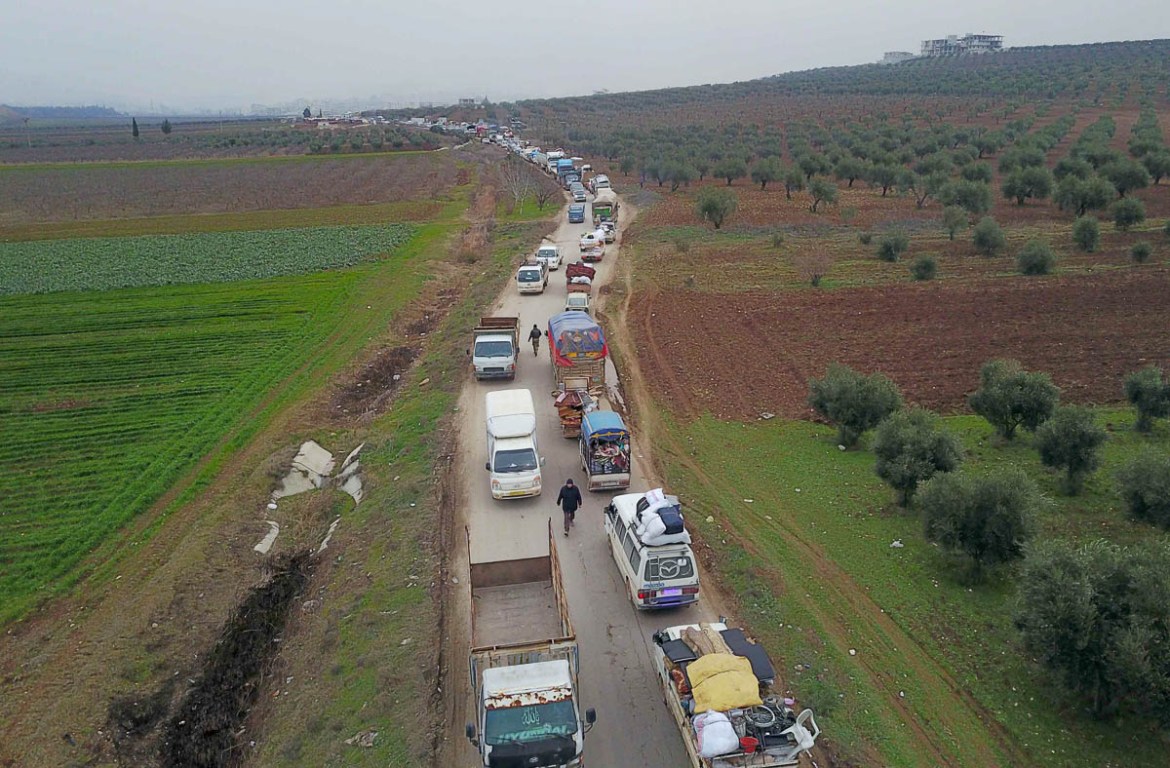 Civilians flee from Idlib to find safety inside Syria near the border with Turkey, Tuesday, Feb. 11, 2020. Syrian opposition activists say rebels have shot down a government helicopter gunship in the