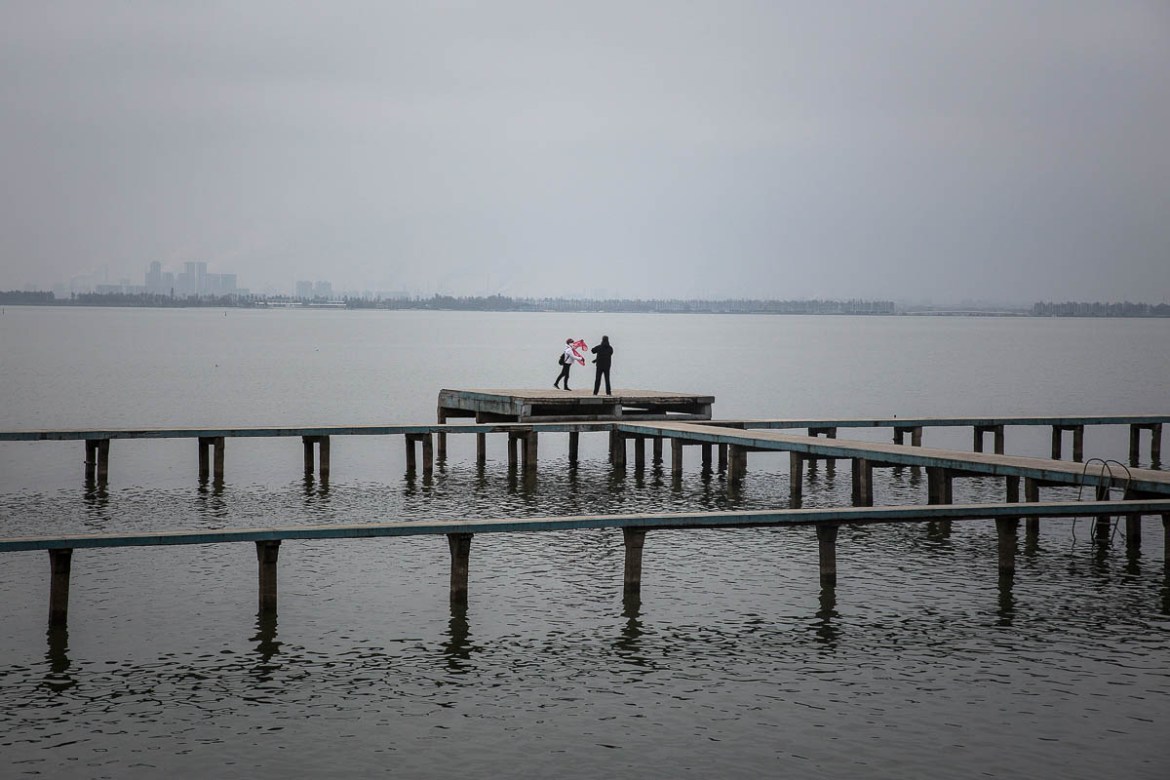 WUHAN, CHINA - FEBRUARY 07: Members of public stand on a jetty in the east lake on February 7, 2020 in Wuhan, Hubei province, China. The number of those who have died from the Wuhan coronavirus, know