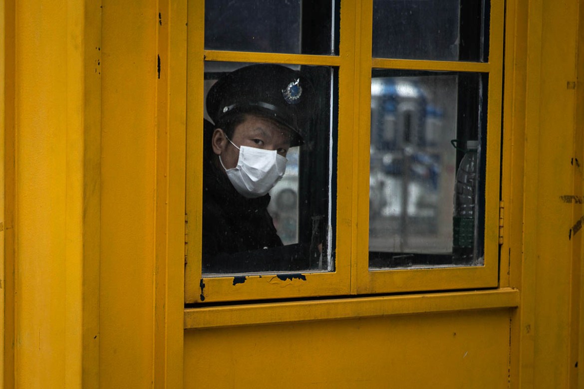 WUHAN, CHINA - FEBRUARY 07: A security guard looks out of the window of a sentry box on February 7, 2020 in Wuhan, Hubei province, China. The number of those who have died from the Wuhan coronavirus,