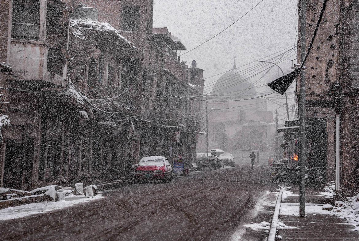 This picture taken on February 10, 2020 amidst a heavy snow storm shows a view along Sarjkhana street in the old town of Iraq''s northern city Mosul with the background showing the dome of the Nuri mos