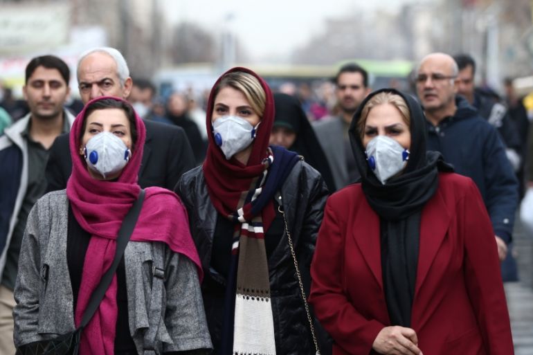 Iranian women wearing protective masks to prevent contracting a coronavirus walk at Grand Bazaar in Tehran