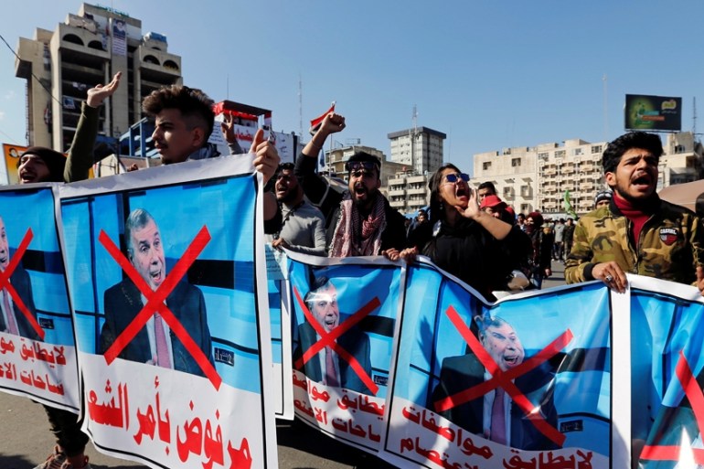 Iraqi demonstrators and university students carry posters depicting the newly appointed Prime Minister of Iraq, Mohammed Tawfiq Allawi, to express their rejection of him,