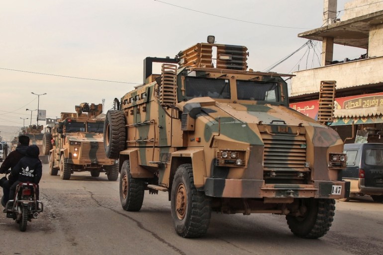 Turkish military vehicles drive in a convoy headed for the south of Idlib province as they pass by the town of Atareb in the western countryside of Aleppo on February 3, 2020. AAREF WATAD / AFP
