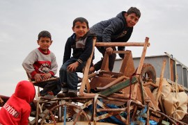 (FILES) In this file photo taken on February 15, 2020 children ride atop a water truck that is also loaded with furniture in the countryside of the village of Saharah, lying on the western edge of Syr