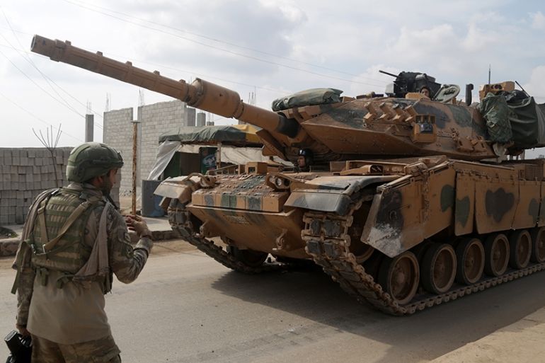 A Turkish soldier patrolling with troops in the town of Atareb in the rebel-held western countryside of Syria''s Aleppo province, walks in front of an M-60T tank, part of a convoy of Turkish military v