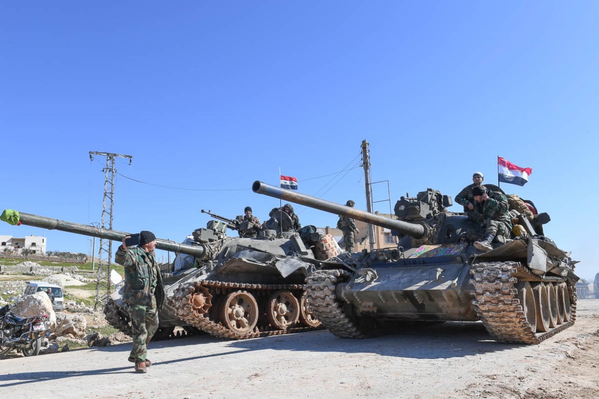Syrian army units advance in the town of al-Eis in south Aleppo province on February 9, 2020, following battles with rebels and jihadists. - Al-Eis, which overlooks the M5, was on a front that saw fie