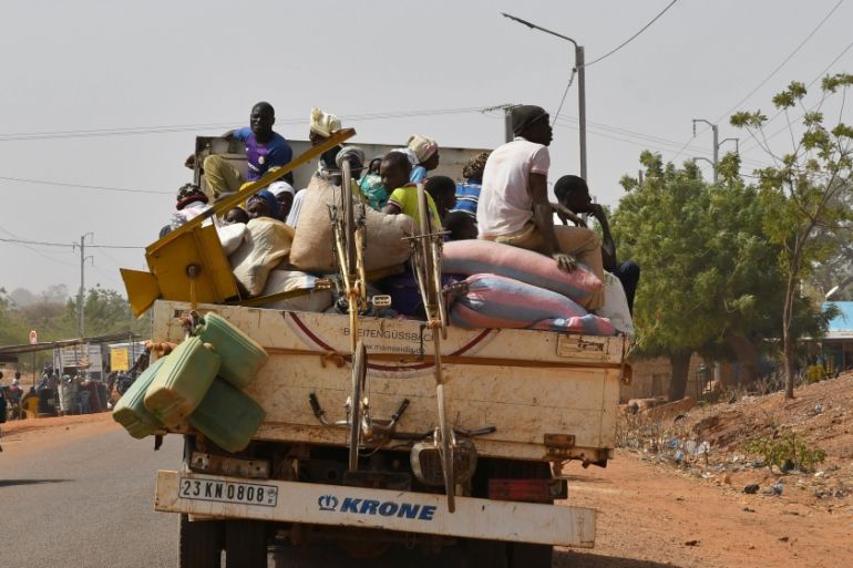 Displaced people, who fled from attacks of armed militants in town of Roffenega, arrive on a truck in the city of Kaya