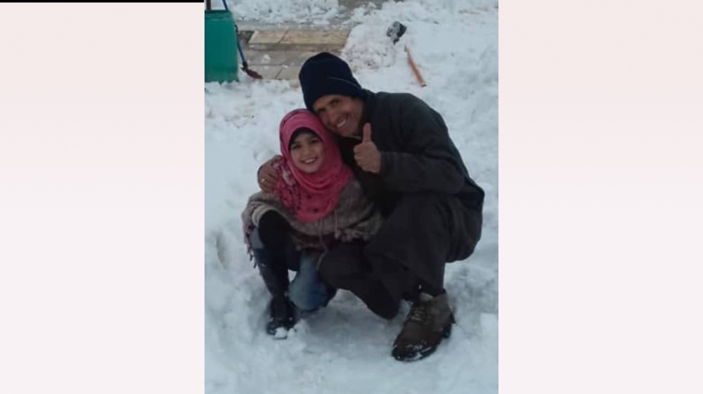 Mustafa Hamadi and his daughter Huda pose in the snow a day before they were killed by carbon monoxide inhalation in Killi, Idlib province