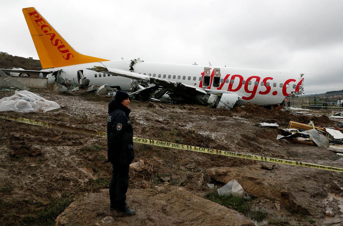 A Police officer stands guard near the Pegasus Airlines Boeing 737-86J plane wreckage, after it overran the runway during landing and crashed, at Istanbul''s Sabiha Gokcen airport, Turkey February 6, 2
