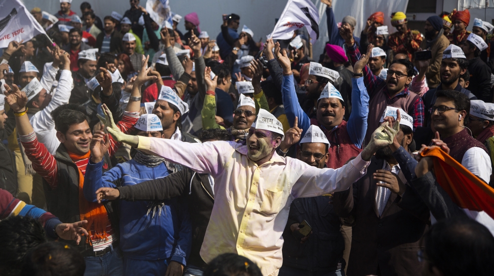 Supporters of Aam Aadmi Party (AAP) chief Arvind Kejriwal throw colour in air as they dance outside their party headquarters after winning the elections on February 11, 2020 in Delhi, India. The rulin