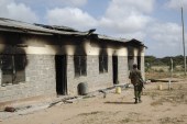A member of Kenya's security forces walks past a damaged police post after an attack by al-Shabab in the settlement of Kamuthe in Garissa county, Kenya on January 13, 2020 [AP]