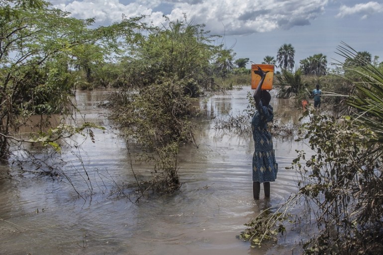A girl fetches water from a river created by flood water near Nsusa Village Island camp for displaced people due to the floods in the Nsanje district of southern Malawi, on March 15, 2019. At least 56