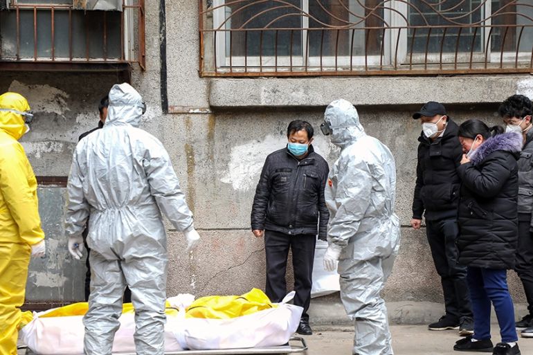 Funeral house workers take the body of a resident, who reportedly died because of the novel coronavirus (2019-nCoV) at home, out of a residential building in Wuhan, in central China''s Hubei province,