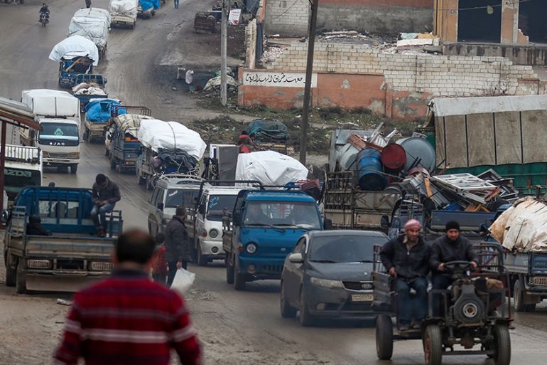 A convoy of trucks transporting Syrians and their belongings drives through the village of al-Mastuma, in the northern countryside of Syria''s Idlib province on January 30, 2020, as thousands of people