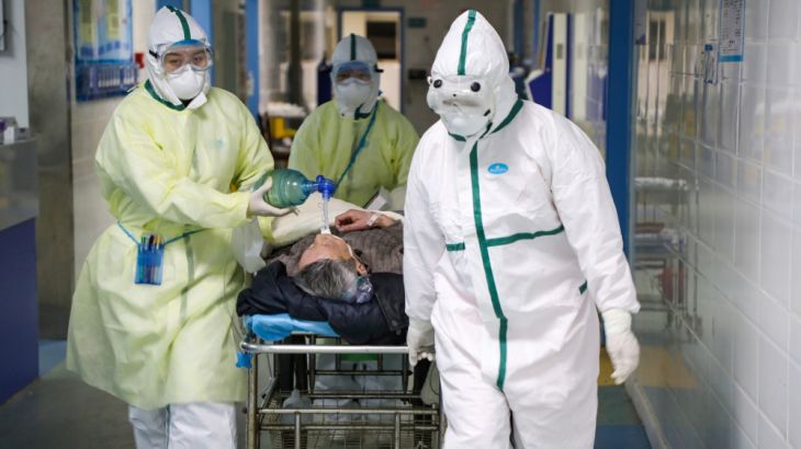 Medical workers in protective suits move a patient at an isolated ward of a hospital in Caidian district following an outbreak of the novel coronavirus in Wuhan