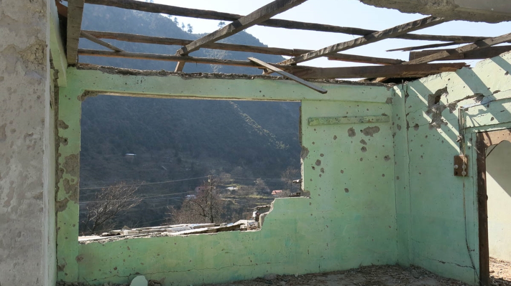 The remains of Muhammmad Siddiq Mir's destroyed living room, looking out upon the Neelum river [Asad Hashim/Al Jazeera]