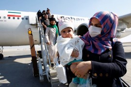Passengers wearing protective masks disembark from a plane upon their arrival at Najaf airport, amid the new coronavirus outbreak, Iraq February 21, 2020. REUTERS/Alaa al-Marjani
