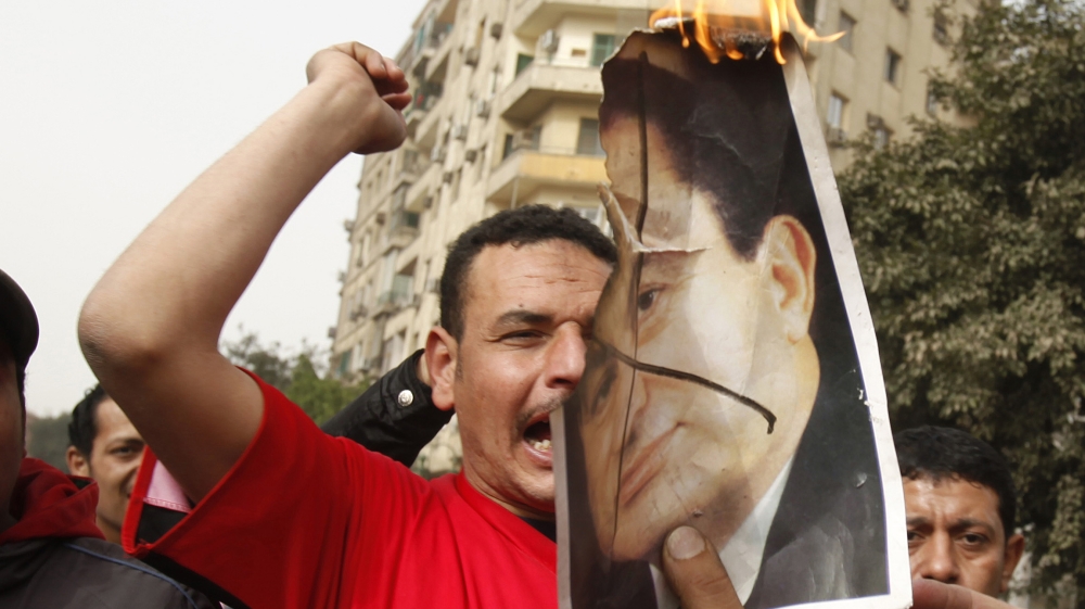 Protesters burn a picture of President Hosni Mubarak as they shout anti-goverment slogans during a demonstration in Cairo January 29, 2011. Thousands of angry Egyptians rallied in central Cairo on Sat
