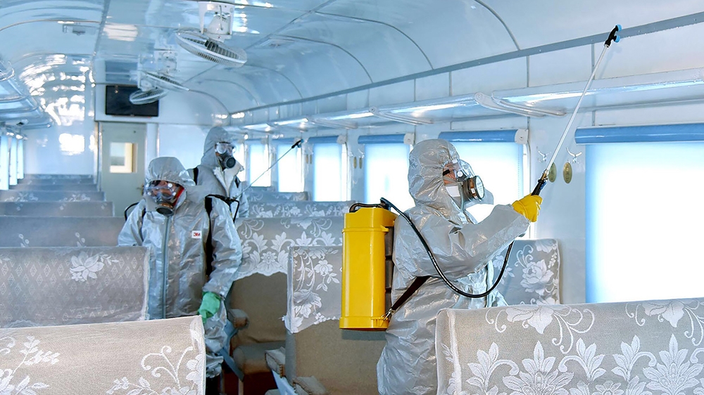 This undated picture released from North Korea's official Korean Central News Agency (KCNA) on February 15, 2020 shows people in protective suits spraying disinfectant at an undisclosed location in No