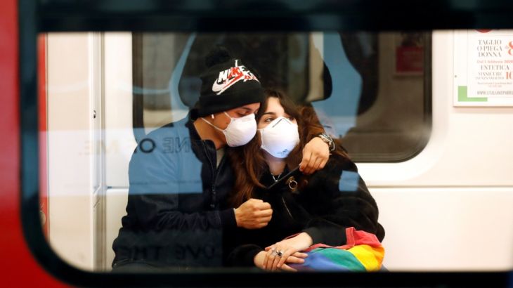 A couple wearing face masks is seen in the subway in Duomo underground station in Milan, as the country is hit by the coronavirus outbreak, Italy February 25, 2020. REUTERS/Yara Nardi