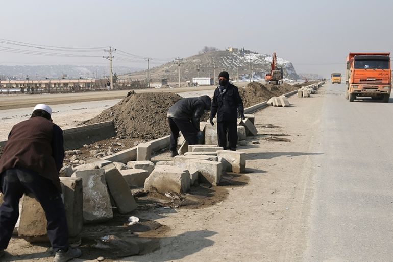 In this Monday, Feb. 10, 2020 photo, Afghan laborers work on a bridge project funded by the government, in Kabul, Afghanistan. Rebuilding war-ravaged Afghanistan has cost thousands of lives according