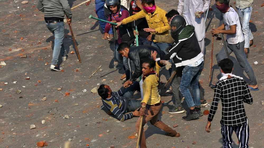 A man is beaten during a clash between people supporting a new citizenship law and those opposing the law in New Delhi
